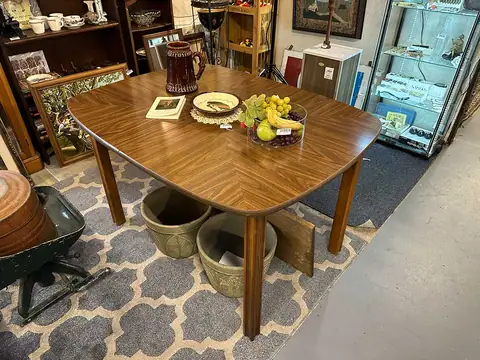 Oval wood-grain mid-century dining table on a patterned rug at Picker Joe's Antique Mall in Savannah, GA