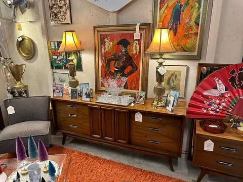 Long walnut credenza with lamps and colorful paintings at Picker Joe's Antique Mall in Savannah, GA