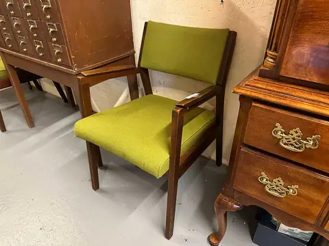 Chartreuse mid-century armchair beside a wood chest at Picker Joe's Antique Mall in Savannah, GA