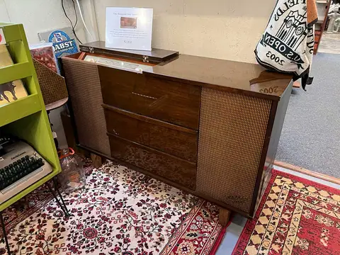 Walnut lowboy dresser on a patterned rug at Picker Joe's Antique Mall in Savannah, GA