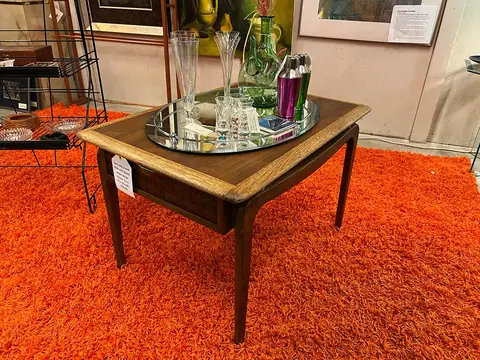 Square wood table with glassware on an orange shag rug at Picker Joe's Antique Mall in Savannah, GA