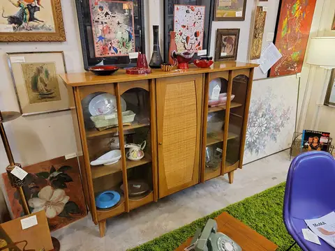 Mid-century cabinet with glass doors and colorful art at Picker Joe's Antique Mall in Savannah, GA