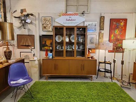 Mid-century china hutch with a purple shell chair on a green rug at Picker Joe's Antique Mall in Savannah, GA