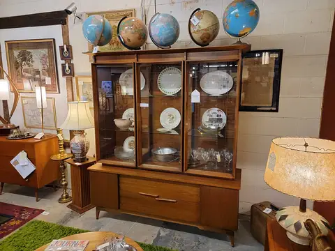 Mid-century china hutch topped with vintage globes at Picker Joe's Antique Mall in Savannah, GA
