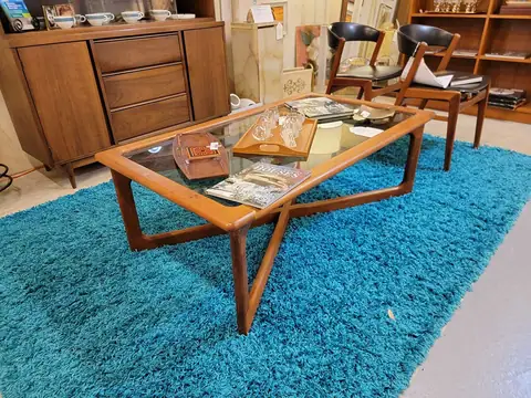 Walnut coffee table with a glass top on a turquoise rug at Picker Joe's Antique Mall in Savannah, GA