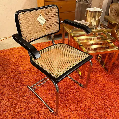 Cane-back cantilever chair on an orange rug at Picker Joe's Antique Mall in Savannah, GA
