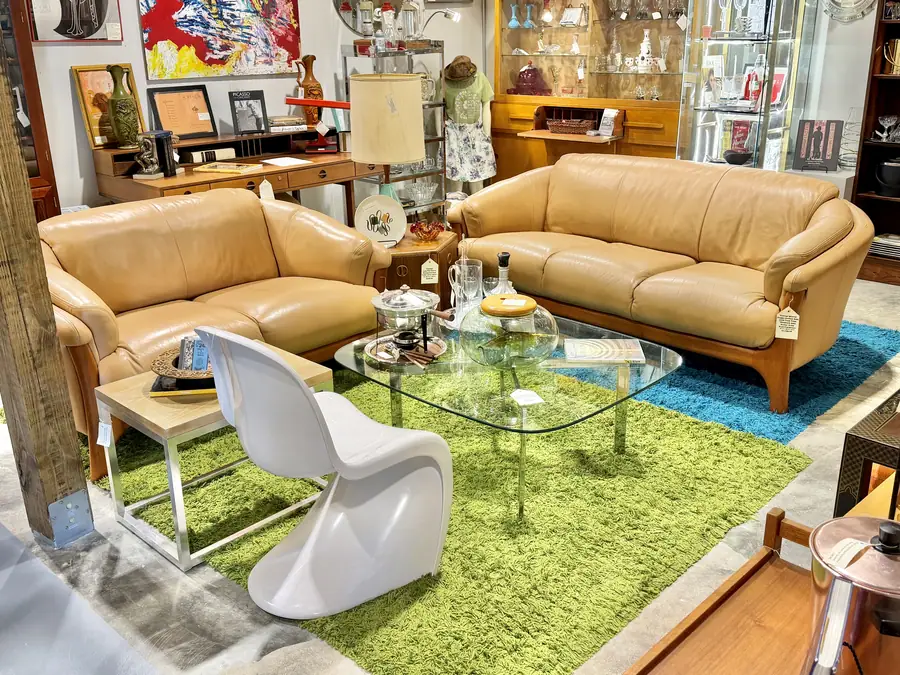 Mid-century sofas and a glass coffee table in a booth at Picker Joe's Antique Mall in Savannah, GA