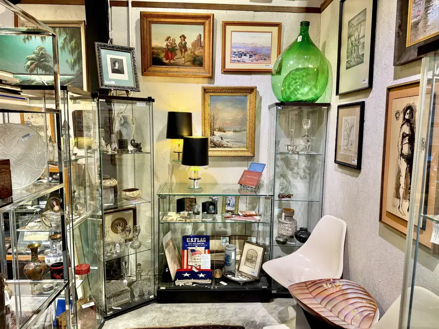 Glass display cabinets of collectibles and paintings at Picker Joe's Antique Mall in Savannah, GA