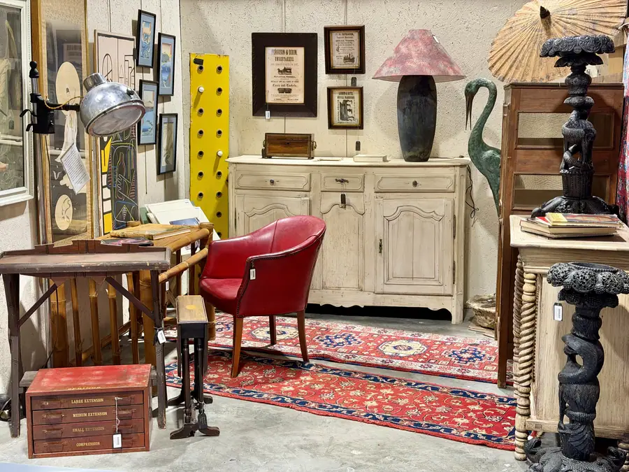 Red chair, sideboard and rugs in a booth at Picker Joe's Antique Mall in Savannah, GA
